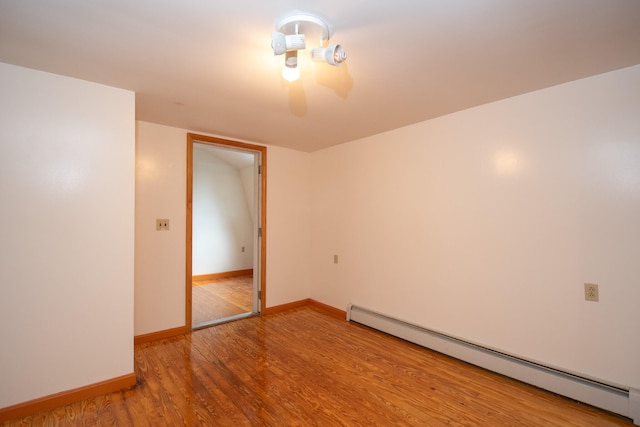 spare room featuring hardwood / wood-style flooring and baseboard heating