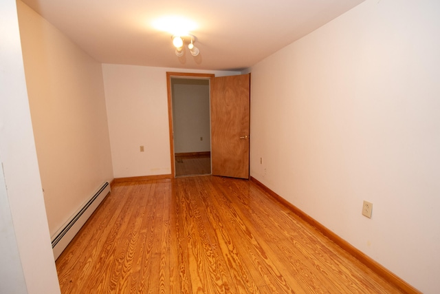 empty room featuring light hardwood / wood-style flooring and a baseboard heating unit