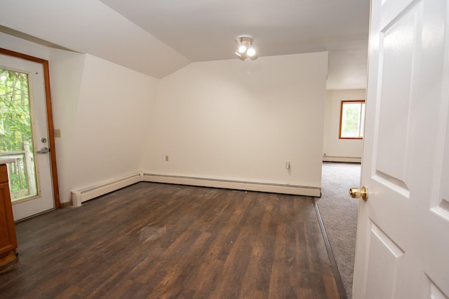 spare room with lofted ceiling, baseboard heating, and dark wood-type flooring