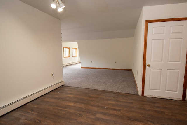 empty room featuring dark hardwood / wood-style floors and a baseboard heating unit