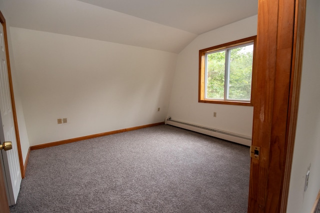 spare room featuring lofted ceiling, carpet, and a baseboard heating unit