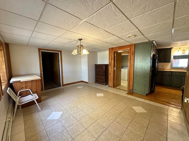 interior space with wood walls, washer / clothes dryer, a chandelier, and light hardwood / wood-style flooring