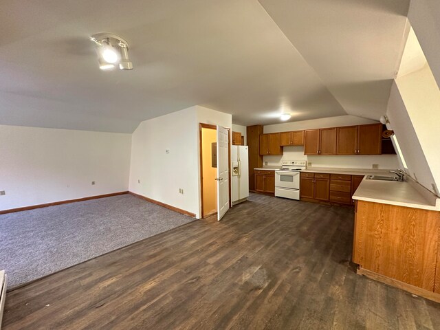 kitchen featuring lofted ceiling, white appliances, sink, and dark wood-type flooring