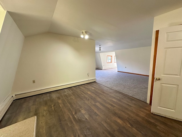 additional living space with vaulted ceiling, a baseboard heating unit, and dark hardwood / wood-style flooring