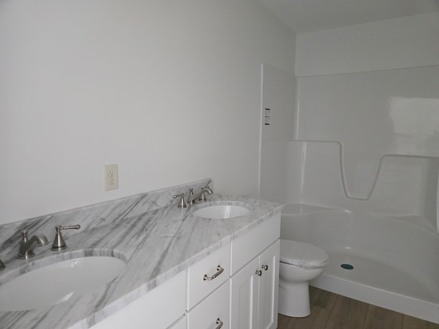 bathroom featuring toilet, a shower, vanity, and wood-type flooring