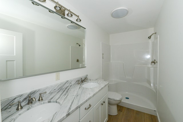 bathroom with vanity, toilet, a shower, and wood-type flooring