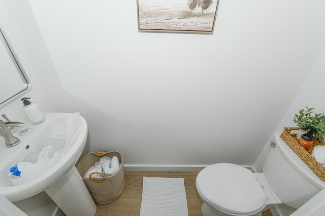 bathroom with wood-type flooring, sink, and toilet