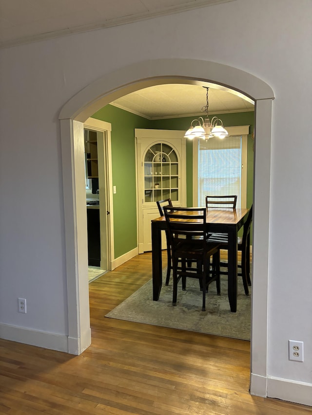 dining room featuring ornamental molding, a chandelier, and hardwood / wood-style floors