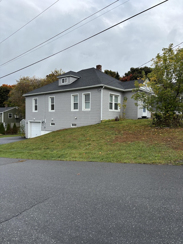 view of home's exterior with a garage and a yard