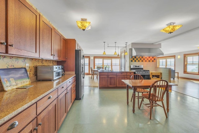 65 Grange Hall Rd, Sullivan, ME 04664 - kitchen featuring wall chimney range hood, backsplash, brown cabinets, stainless steel appliances, and a sink