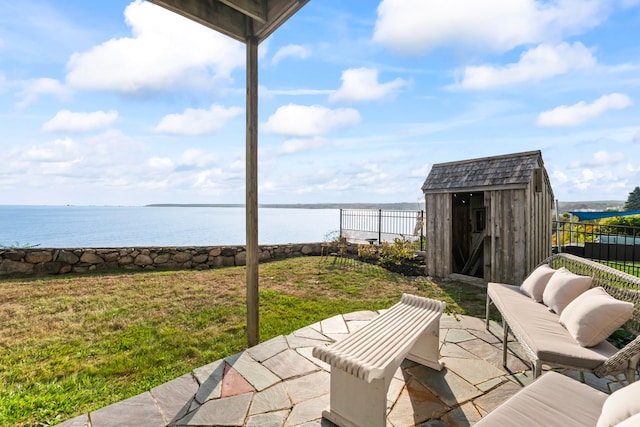 view of patio featuring a shed and a water view