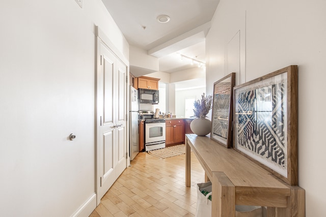 kitchen with rail lighting, stainless steel refrigerator, and white range with electric cooktop