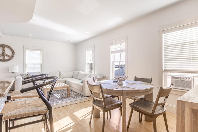 dining area featuring cooling unit, plenty of natural light, and light hardwood / wood-style flooring