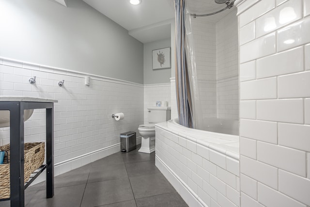 bathroom featuring tile patterned floors, shower / tub combo with curtain, toilet, and tile walls