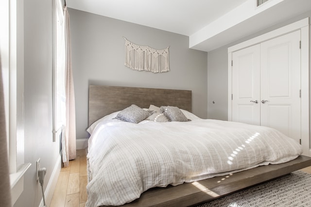 bedroom with light wood-type flooring and a closet