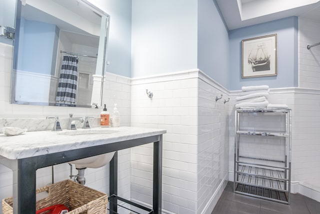 bathroom featuring tile patterned flooring, tile walls, and a shower with curtain