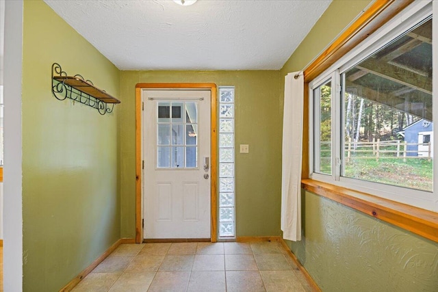 foyer with a textured ceiling and light tile patterned floors