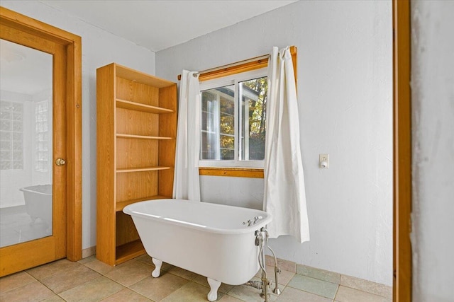 bathroom featuring tile patterned flooring and a tub to relax in