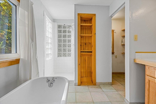 bathroom with tile patterned flooring, vanity, and shower with separate bathtub