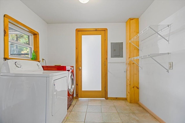 laundry room with electric panel, washer and dryer, and light tile patterned floors