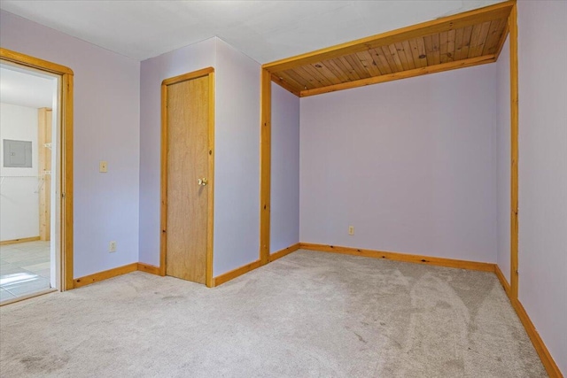 carpeted spare room with electric panel and wood ceiling