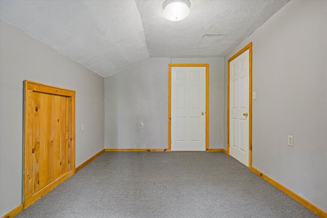 additional living space with carpet floors, a textured ceiling, and lofted ceiling