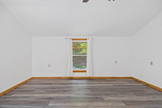 unfurnished room with hardwood / wood-style flooring, ceiling fan, and vaulted ceiling