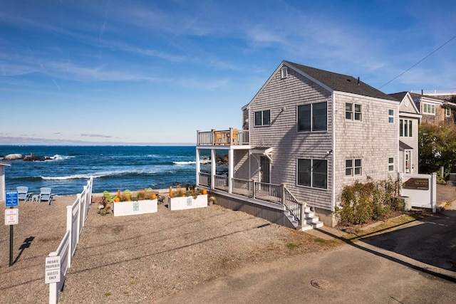 view of property exterior featuring a water view and a balcony