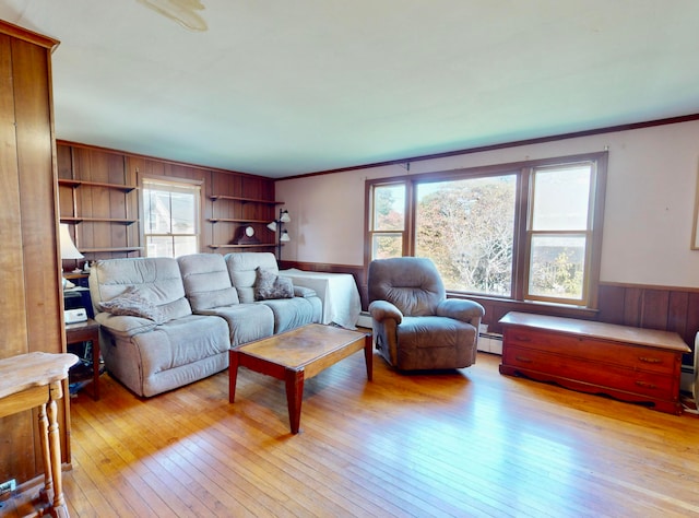 living room with light wood-type flooring, a baseboard heating unit, and plenty of natural light