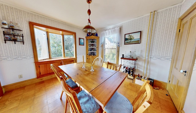 dining space featuring baseboards, wallpapered walls, and crown molding