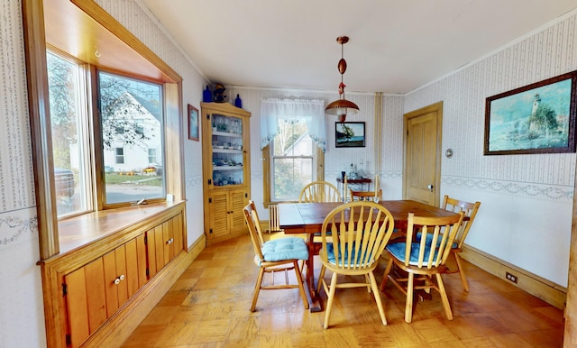 dining area with ornamental molding, a healthy amount of sunlight, baseboards, and wallpapered walls