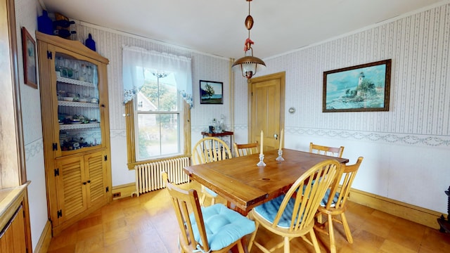 dining area with ornamental molding, radiator heating unit, light floors, and wallpapered walls