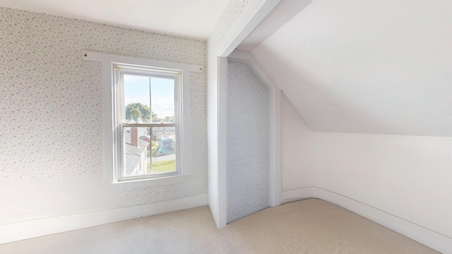 bonus room featuring light colored carpet and lofted ceiling