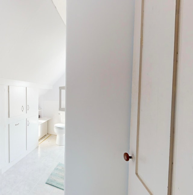 bathroom featuring toilet and lofted ceiling