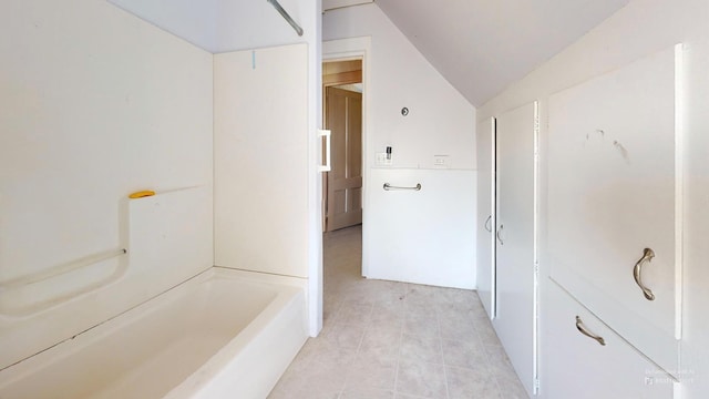 bathroom with tile patterned floors and lofted ceiling
