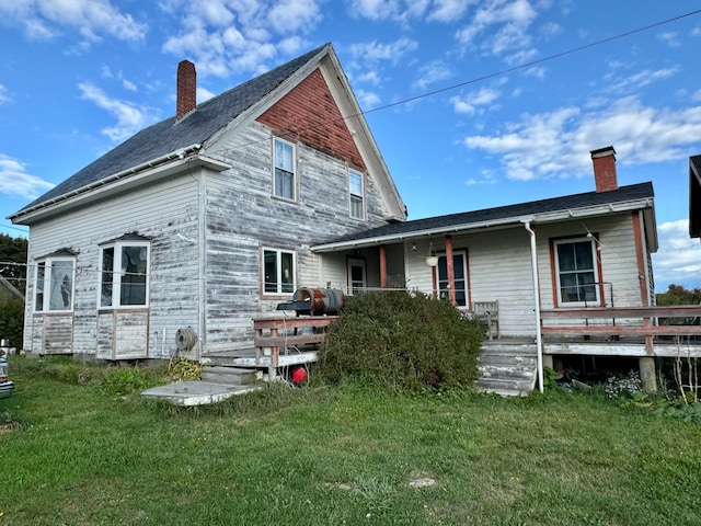 rear view of property featuring a lawn