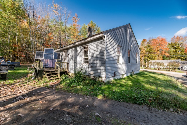 view of property exterior with a yard and a deck