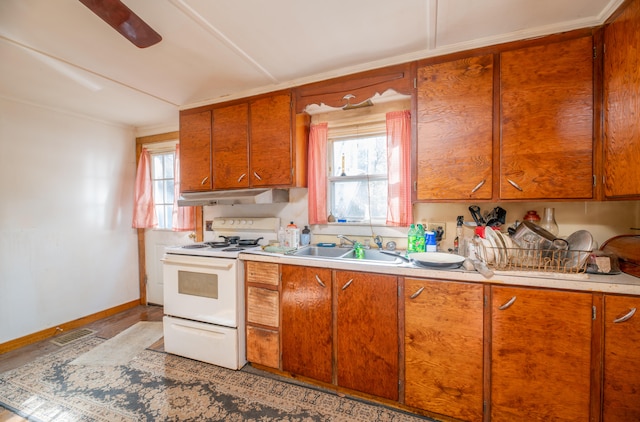 kitchen featuring a healthy amount of sunlight, white range with electric cooktop, and sink