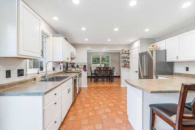 49 Balsam Dr, Waldoboro, ME 04572 - kitchen featuring sink, a kitchen breakfast bar, kitchen peninsula, white cabinets, and appliances with stainless steel finishes