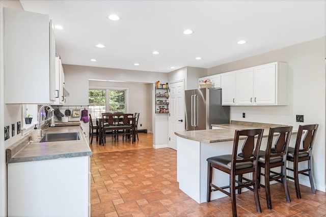 49 Balsam Dr, Waldoboro, ME 04572 - kitchen featuring sink, kitchen peninsula, a kitchen bar, high quality fridge, and white cabinets
