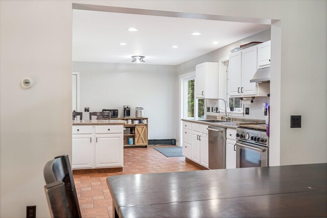 49 Balsam Dr, Waldoboro, ME 04572 - kitchen featuring kitchen peninsula, appliances with stainless steel finishes, ventilation hood, sink, and white cabinets