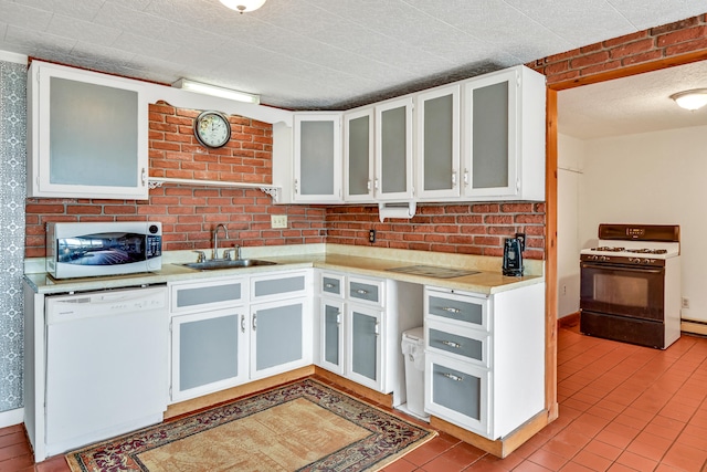 kitchen featuring light tile patterned floors, white cabinets, sink, and white appliances