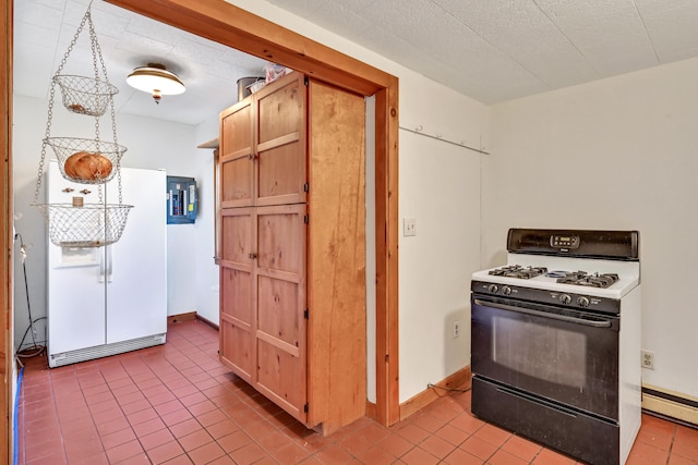 kitchen featuring a textured ceiling, baseboard heating, light tile patterned floors, and white appliances