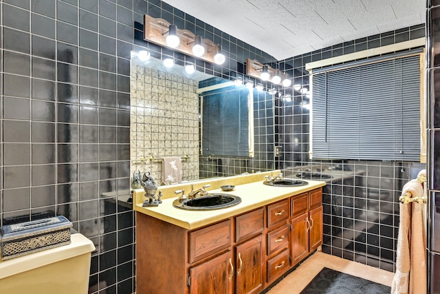 bathroom featuring tile walls, vanity, and toilet