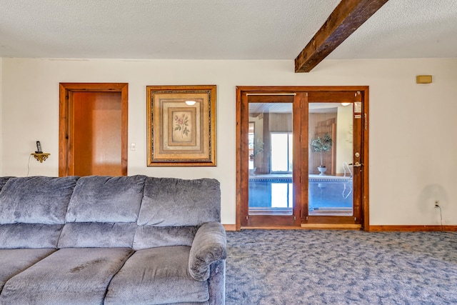 living room with beamed ceiling, carpet, and a textured ceiling