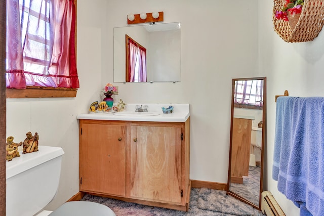 bathroom with vanity, toilet, and a baseboard heating unit