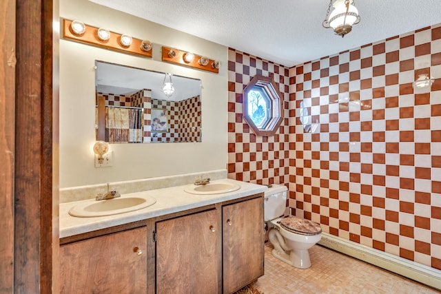 bathroom with vanity, tile patterned flooring, toilet, and a textured ceiling