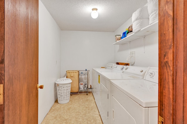 laundry area with a textured ceiling and washer and dryer