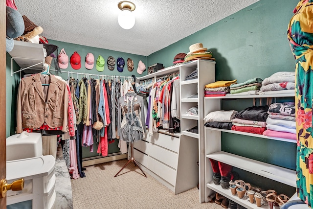 spacious closet with carpet floors and a baseboard heating unit