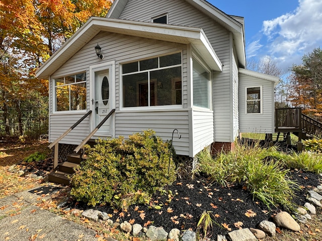 view of front facade featuring a sunroom and a wooden deck